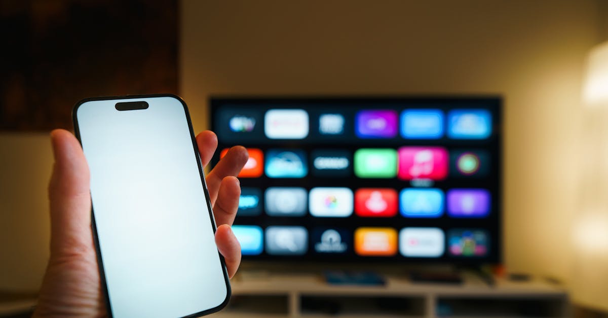 A smartphone in focus with a smart TV displaying apps in a cozy living room.